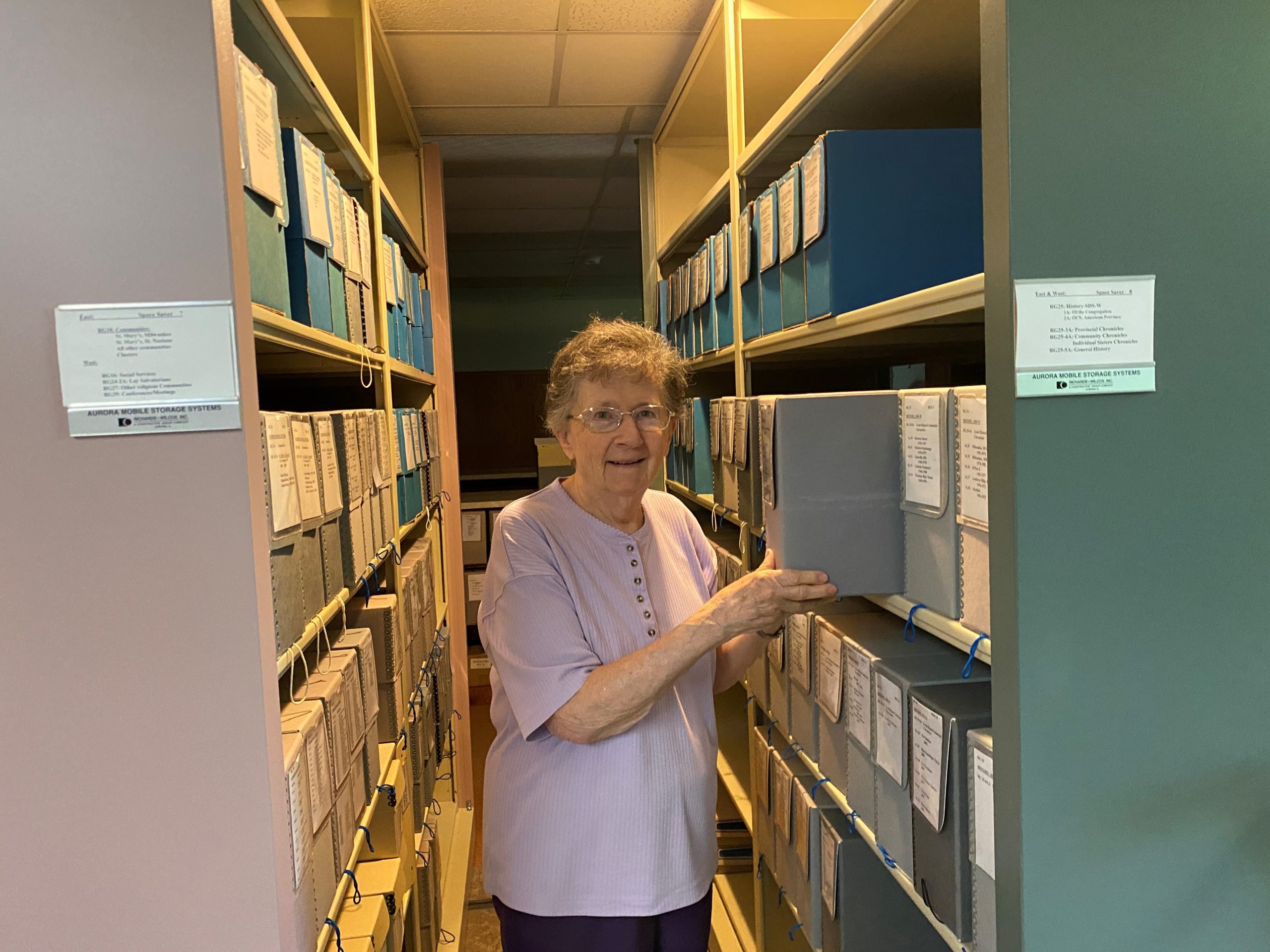 Sister Mary Jo pulling box from archival storage