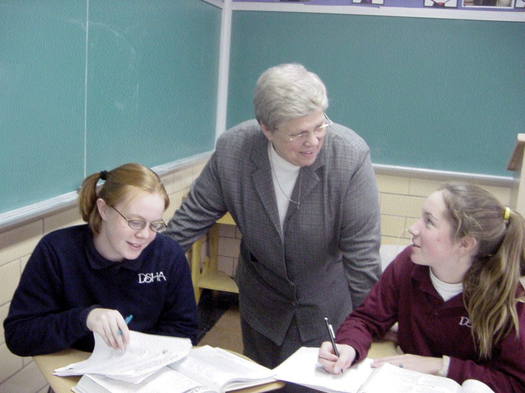 Sister Virginia Honish between two DSHA high school girls.